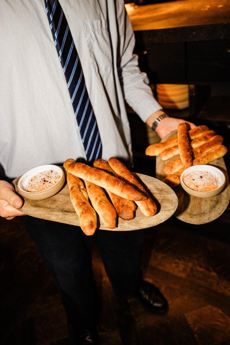 A server carrying pizza crust breadsticks