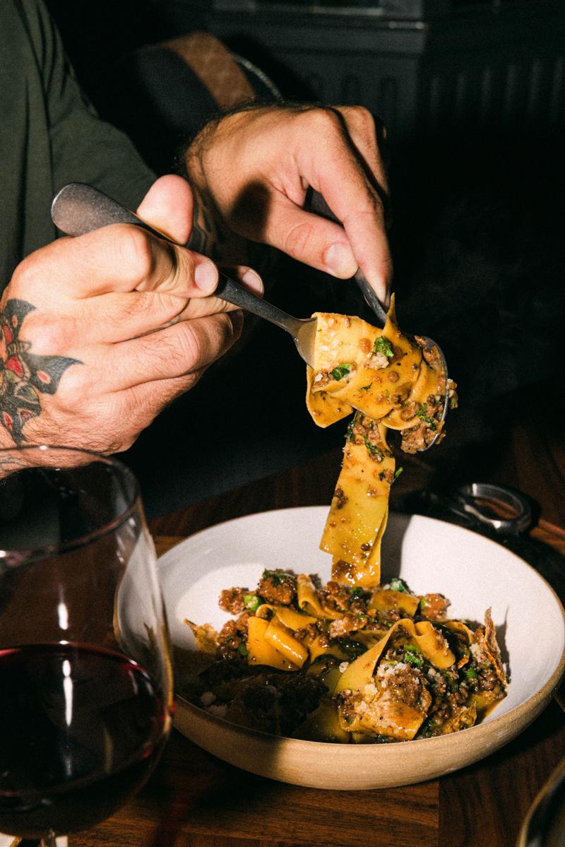 A forkful of pappardelle lifted from the bowl