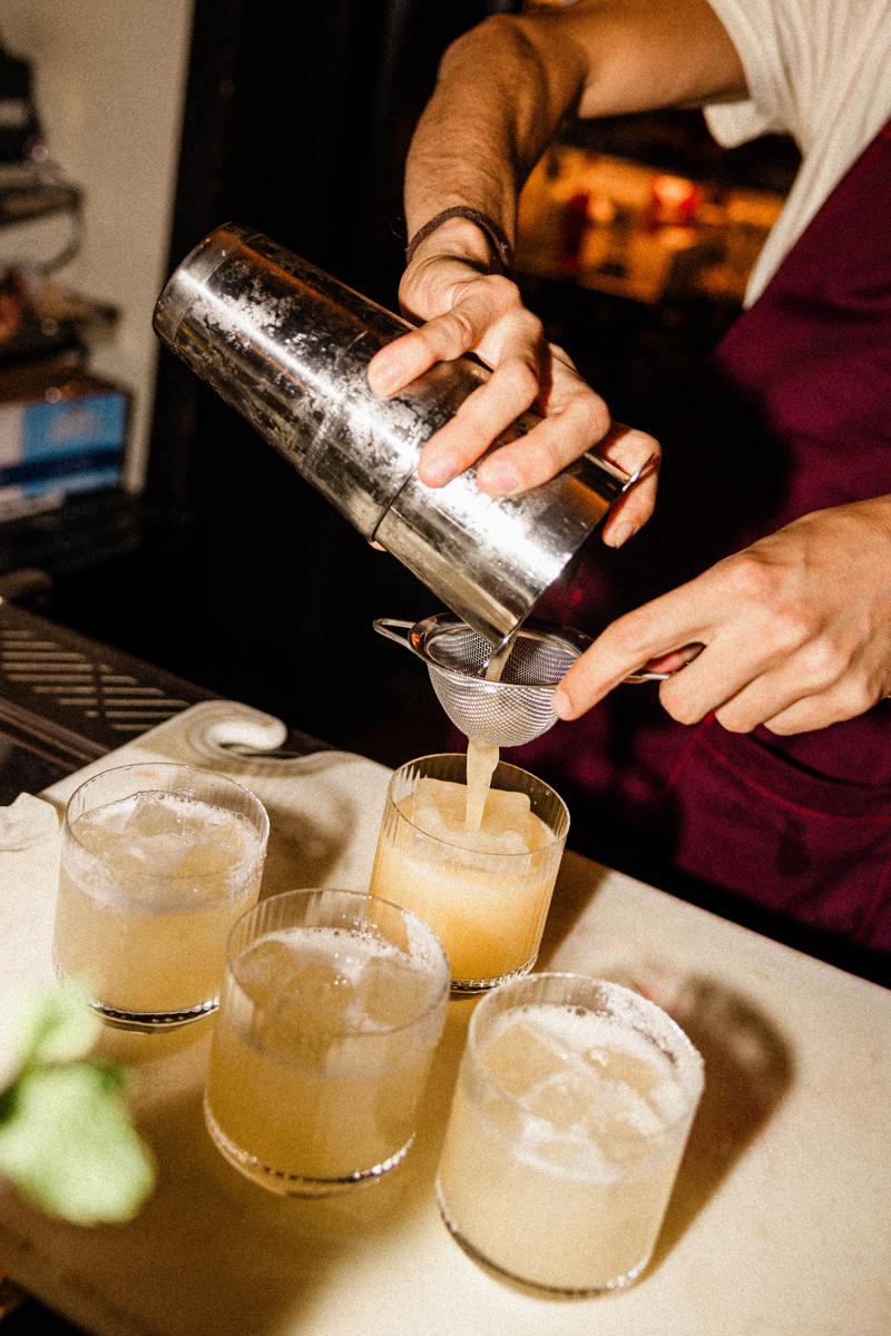 Cocktails being strained into glasses